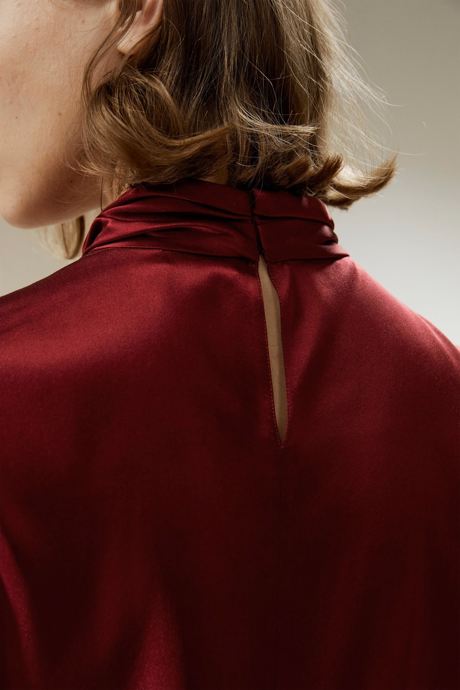 Camisa con pliegues asimétricos adornados