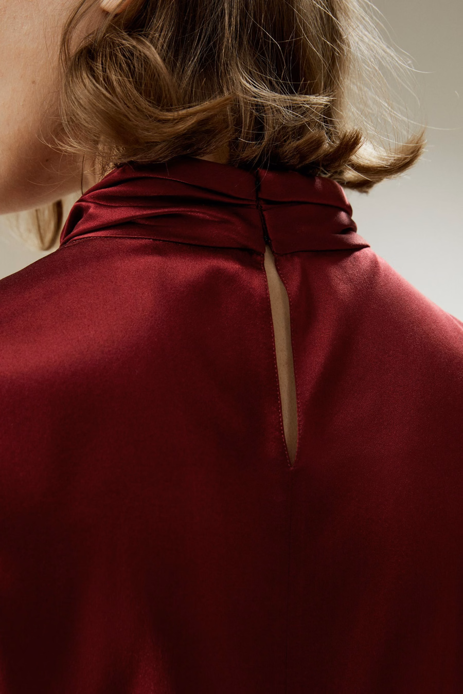 Camisa con pliegues asimétricos adornados